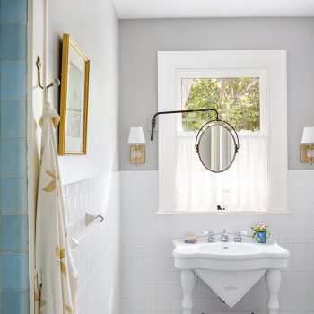Restored Guest Powder Bathroom With Original Blue Shower Tiles, New Mosaic Penny Floor Tile, Antique Mirror, And Vintage Inspired Sink.